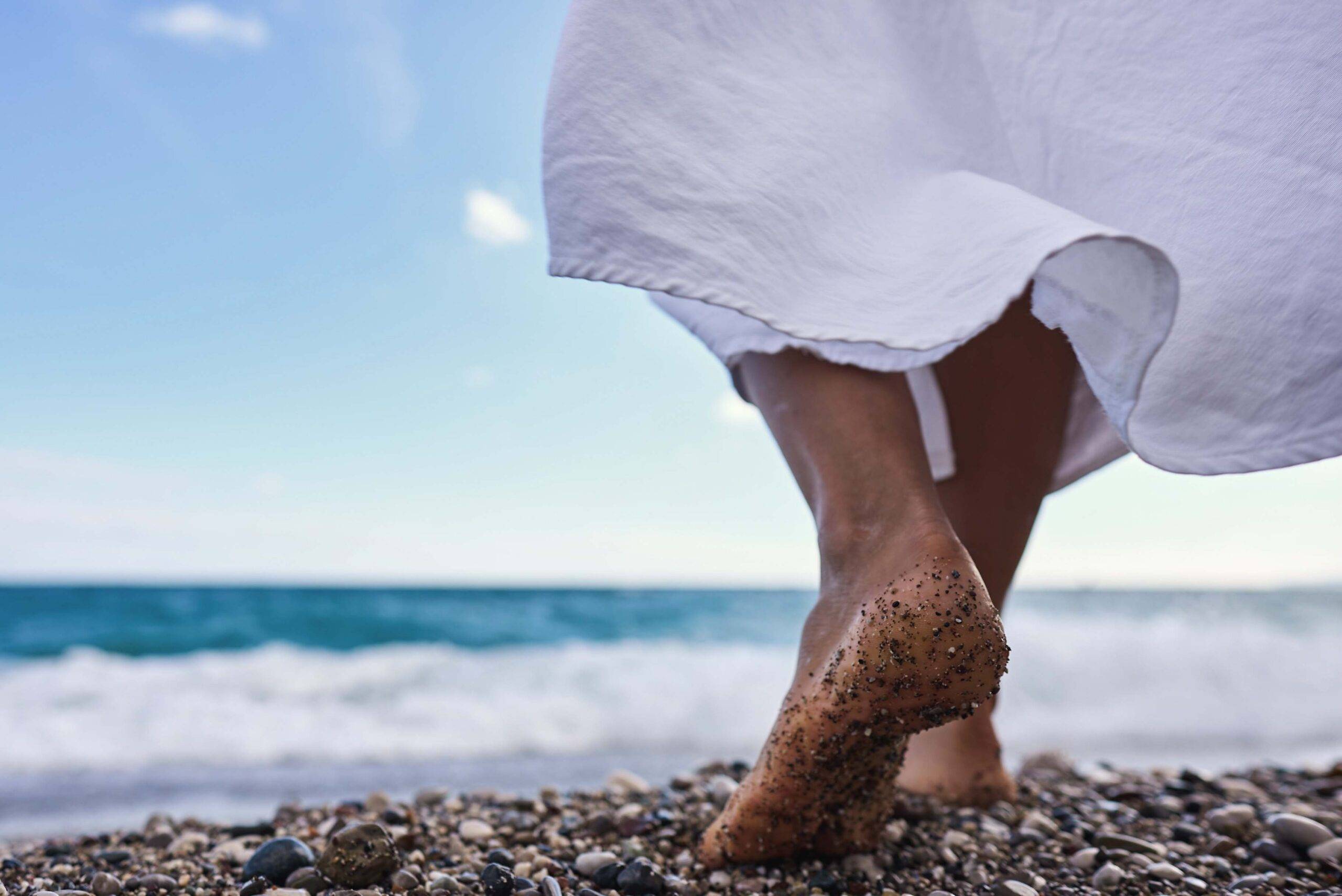 Barefoot woman walking on a rocky beach